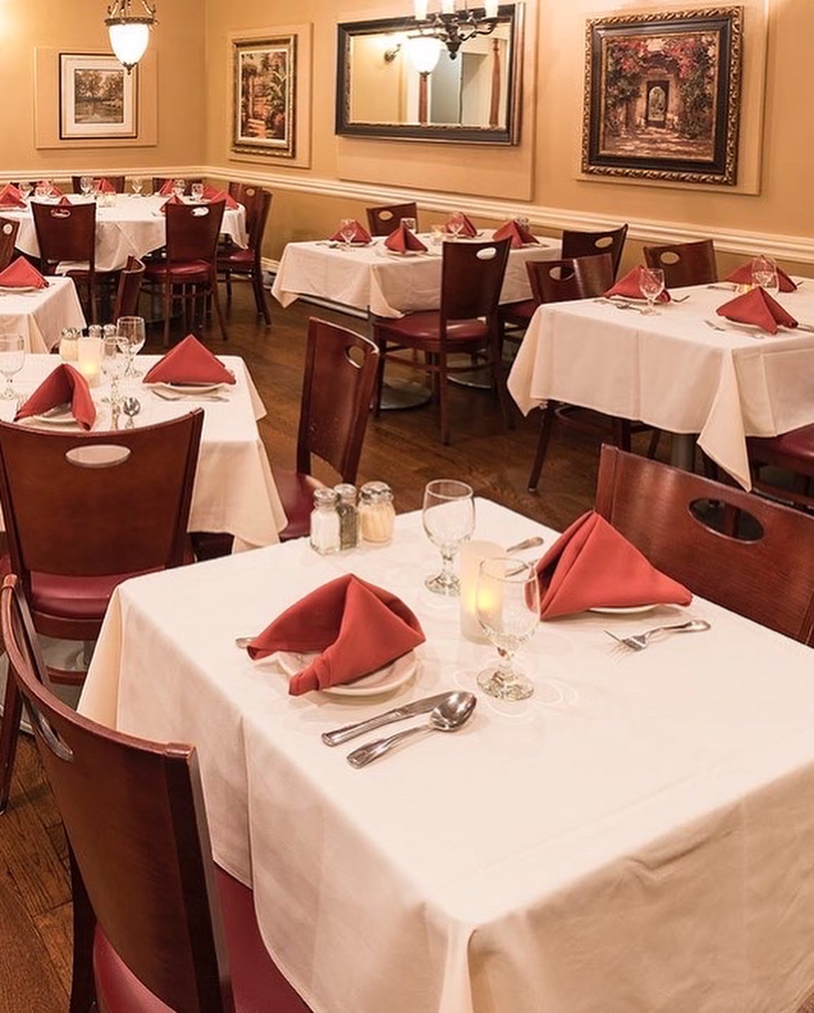 Paradiso dining room set with white tablecloths and red napkins
