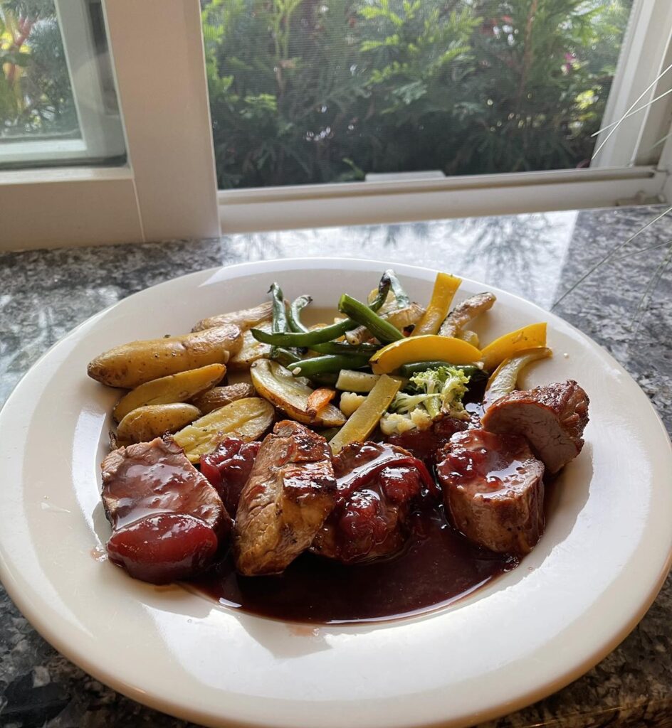 Pork tenderloin with cherry port sauce, fingerling potatoes and vegetables
