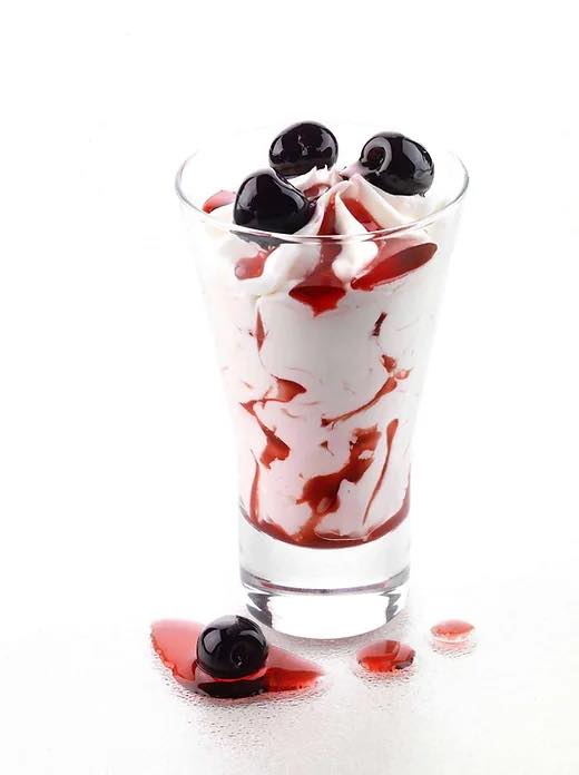Whipped cream parfait with black cherries and cherry syrup